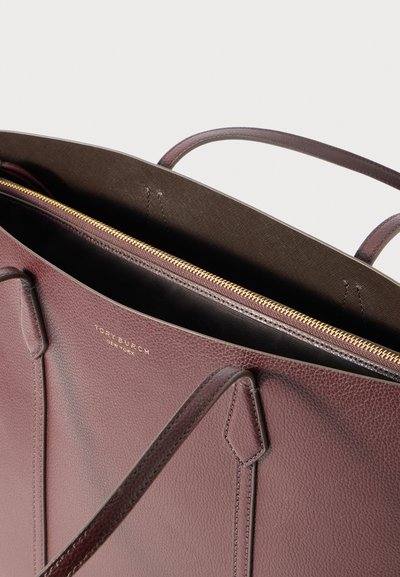 Μπορντό δερμάτινη τσάντα tote με διπλές λαβές, χρυσό φερμουάρ και καφέ επένδυση εσωτερικά. Διαθέτει λογότυπο στο εξωτερικό και υφή επιφάνειας.