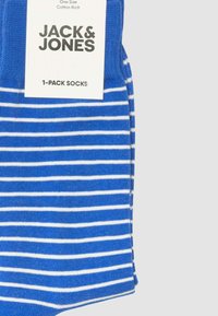 Calze in cotone blu con strisce bianche, etichettate "Jack & Jones", esposte con un'etichetta che indica una taglia e confezione singola.