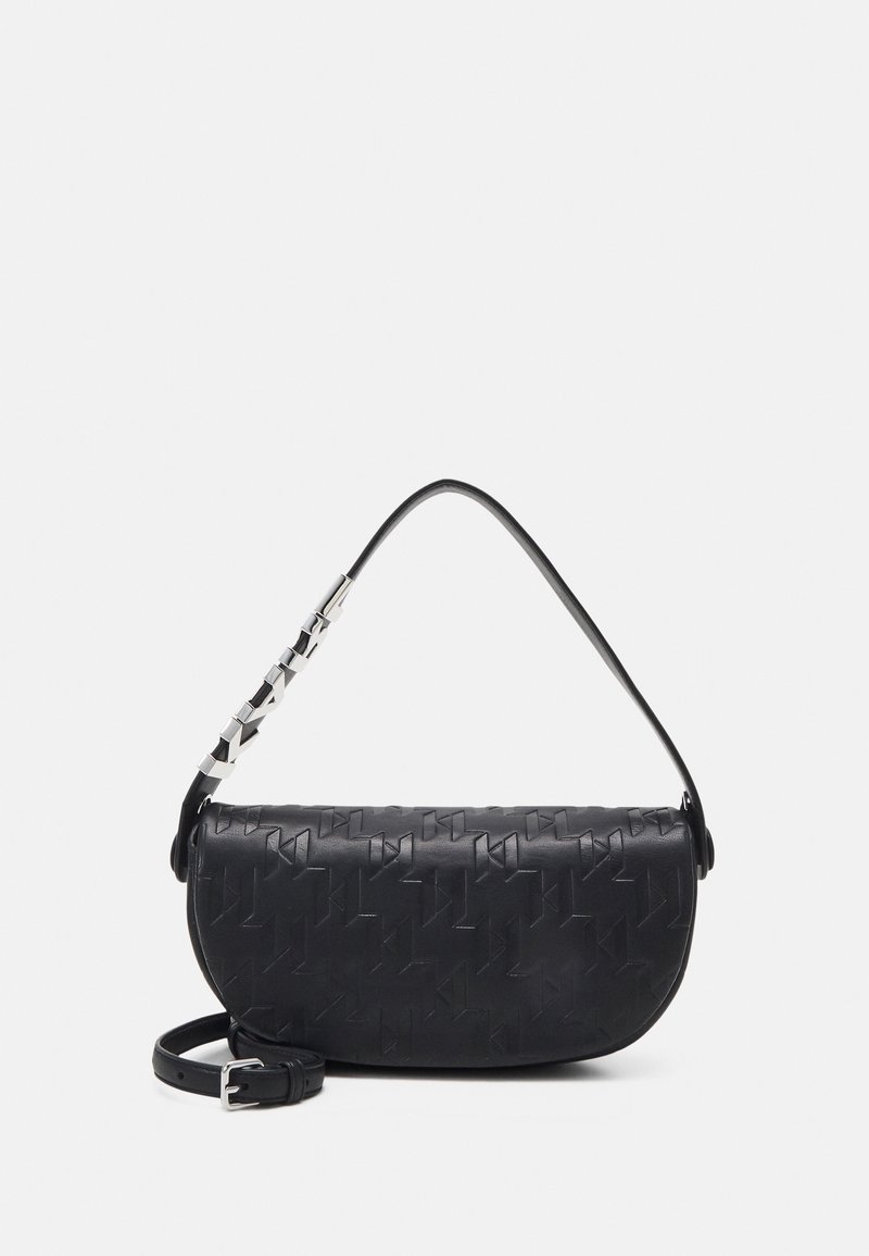Sac à bandoulière en cuir noir avec motif géométrique embossé, détail chaîne argentée sur la sangle et ceinture ajustable supplémentaire sur fond blanc.