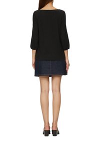 Zwarte longsleeve top met een ronde halslijn, gecombineerd met een denimrok. De rok heeft contrasterende stiksels en een uitlopende zoom.