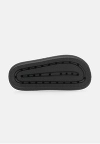 Black rubber sneaker sole with a textured zigzag pattern, featuring several holes for airflow, and a smooth, rounded toe section.