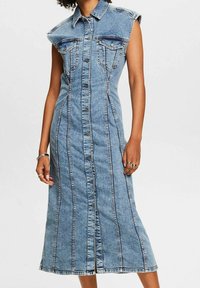 Denimklänning med knapplåst fram, krage, ärmlös design och två bröstfickor samt en medellång, rak passform.