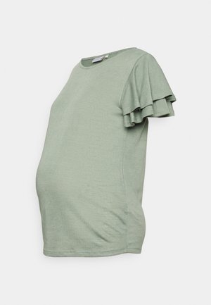 Top premaman verde salvia con maniche corte a strati e volant, e scollatura rotonda, esposto su uno sfondo bianco.