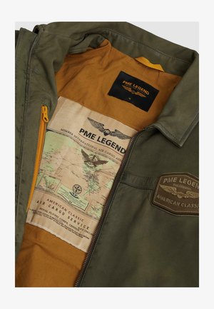 Chaqueta verde con forro marrón que presenta parches de PME Legend y un detallado estampado de mapa de estilo vintage en el interior de la chaqueta.