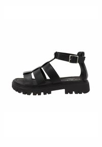 Sandali neri con cinturini, suola spessa, tomaia in pelle, cinturino alla caviglia regolabile e suola resistente per una buona aderenza. Design piatto e semplice dettaglio con fibbia.