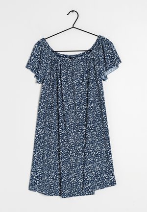 Robe florale bleue avec de courtes manches froncées, présentant un corsage ajusté et une jupe ample et fluide. Tissu en coton avec un motif de fleurs blanches.
