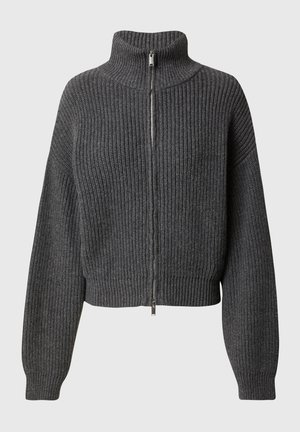 Tummanharmaa ribbiknitti neulepaita, jossa on pitkät hihat, korkea kaulus ja täyspitkä hopeinen vetoketju edessä.