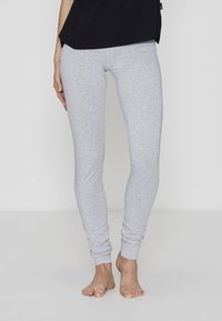 Grå heather jersey leggings med en tætsiddende design, blød tekstur og ankelmanchetter, parret med en løs sort top.