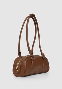 Borsa a mano in pelle marrone con due manici allungati, chiusura con zip e forma rettangolare arrotondata. Texture liscia con accenti minimalisti.