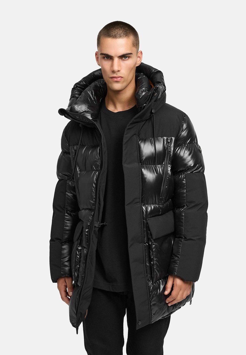 Svart puffjacka med en glänsande yta, utrustad med huva, flera fickor och dragkedjestängning. Tighta puffar ökar isoleringen.