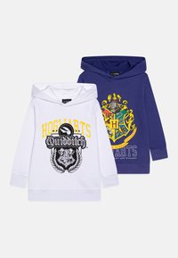 Dva dukserice: jedna bijela s žutim natpisom "HOGWARTS Quidditch" i crnim grbom; jedna tamnoplava s šarenim grbom Hogvorts i bijelim natpisom.