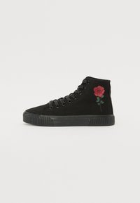 Adidași negri tip glezna din pânză, cu un design brodat cu o trandafir roșu pe partea superioară, cu șireturi negre și o talpă din cauciuc texturată.
