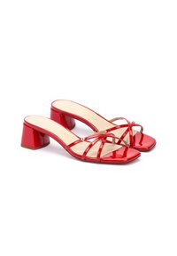 Sandales à talons blocs en cuir verni rouge avec des bouts carrés et plusieurs brides croisées. Texture lisse avec une finition brillante.