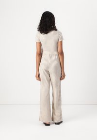 Stripete jumpsuit i krem og beige, med korte ermer, en tettsittende midje og vide bukser. Mynte stoff med en teksturert overflate.