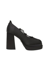 Chaussure à talon haut plateforme noire avec talon bloc épais et brides décoratives sur le dessus, vue de profil sur fond blanc.
