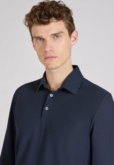 Navy poloshirt met lange mouwen, een gestructureerde kraag, drieknoopsluiting en een gladde textuur. De stof lijkt lichtgewicht en ademend.