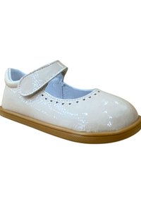 Zapato Mary Jane de charol blanco con punta redonda, cinta de velcro ajustable y detalles perforados a lo largo del borde. Suela de goma marrón claro.