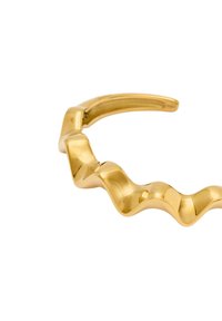 Bracciale rigido ondulato color oro realizzato in metallo lucido con una superficie liscia e accenti geometrici, caratterizzato da un design a loop continuo.