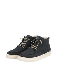 Baskets montantes en suede noir avec des lacets beiges, des semelles en caoutchouc blanc et des accents cousus. Doublure douce visible au niveau du col.