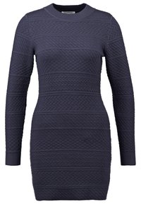 Robe en tricot bleu marine à manches longues, cintrée, avec des motifs géométriques texturés et torsadés, et un col rond.