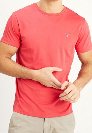 Czerwona bawełniana koszulka z krótkim rękawem, okrągłym dekoltem i małym logo na piersi. Gładka faktura, dopasowany krój.