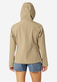 Beige hoodie met een gladde, matte afwerking, voorzien van een nauwsluitende pasvorm en een drukknoopdetail bij de halslijn, gecombineerd met denim shorts.