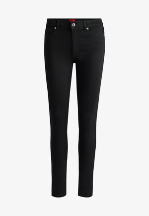 Svarta denim skinny jeans med en åtsittande design, silverdetaljer, dragkedja fram och bakfickor; har en röd märkesflik på midjebandet.