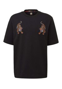 Svart bomulls t-shirt med två broderade tigrar på bröstet, rund halsringning och korta ärmar. Slät textur, avslappnad passform.