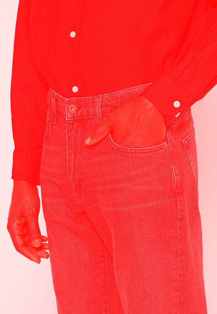 Rode langemouwen shirt met knoopmanchetten, gecombineerd met rode denim jeans. Opvallende kenmerken zijn een getailleerde pasvorm en een klassieke 5-pocket ontwerp.