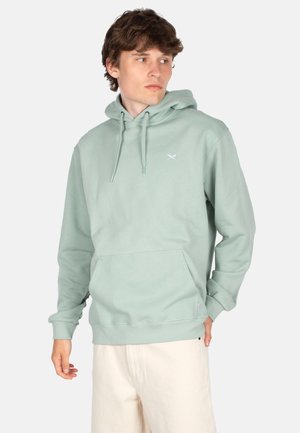 Hellgrüner Hoodie aus weichem Stoff, mit einer Fronttasche, Kordeln und einem kleinen weißen Logo auf der Brust. Glatte Textur.