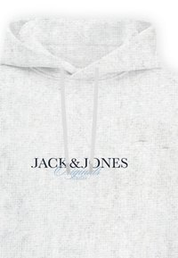 Sudadera gris claro con cordones, con el texto centrado "JACK & JONES Originals Studio" en fuente negra y azul claro.