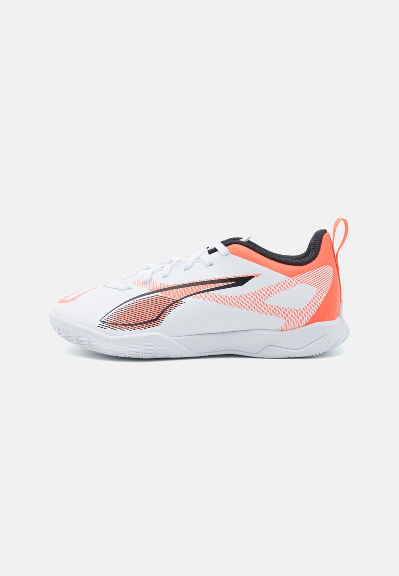 White athletic shoe with orange accents, textured panels, and a sleek design. Features a padded collar and rubber sole for traction.