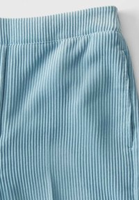 Shorts en velours côtelé bleu clair avec une texture à côtes verticales, dotés d'une taille élastique et de poches latérales. Fini de tissu lisse.