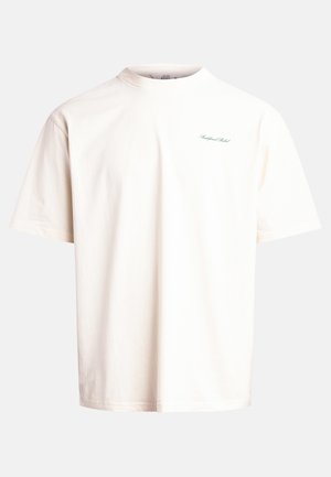 T-shirt à manches courtes, col rond en coton écru avec un logo texte vert subtil sur la poitrine, présentant une coupe décontractée et une texture douce.