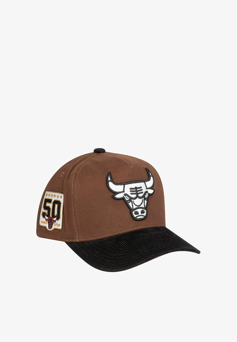 Brauner Baseballschläger mit einem schwarzen Cordura-Schirm, versehen mit einem weißen gestickten Stier-Logo und einem Gedenkabzeichen zum 50-jährigen Jubiläum auf der Seite.