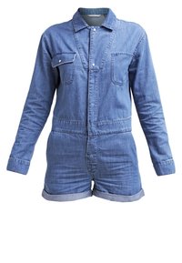 Combinaison en denim bleu clair. Manches longues, fermeture à boutons sur le devant, deux poches poitrine et revers aux manches du short. Texture lisse, design décontracté.