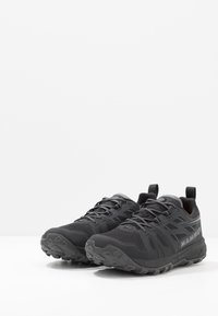 Schwarze Trail-Running-Schuhe mit strukturiertem Synthetik-Obermaterial, grauen Akzenten und robuster Gummisohle. Verfügt über Schnürsenkel und Zuglaschen für einfachen Einstieg.