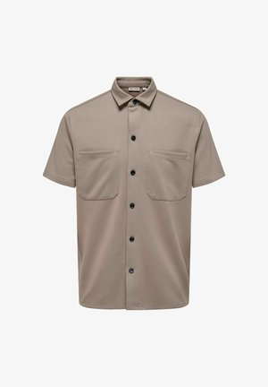 Šviesiai kreminės spalvos trumpas rankovėmis marškiniai iš tekstūruoto audinio su smaigalio apykakle, dviem krūtinės kišenėmis ir juodais mygtukais.