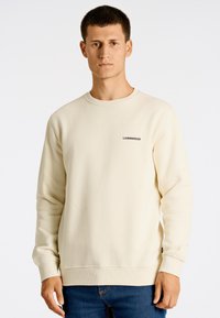 Sudadera beige de manga larga con puños acanalados. Presenta un cuello redondo y un pequeño texto negro "LINDENBRGH" en el pecho. Acabado de tejido suave.