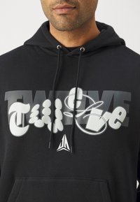 Felpa nera con cappuccio caratterizzata da una grande stampa grafica con il testo "TWELVE" e "FIVE" in bianco e grigio, con lacci e un piccolo dettaglio del logo.