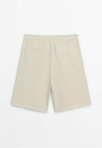 Beige farkut suoralla leikkauksella, pehmeästä kankaasta. Varustettu kahdella takataskulla ja yksinkertainen muotoilu, jossa ei ole näkyvää metalliosaa tai kuvioita.