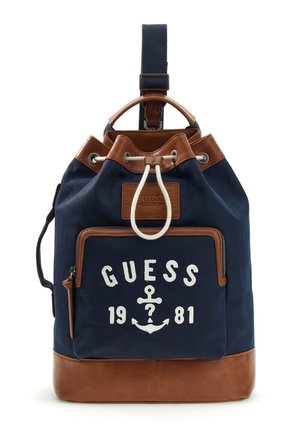 Sac à dos bleu marine et marron avec poche avant zippée, fermeture par cordon de serrage, et texte "GUESS 1981" avec logo ancre sur la poche avant.