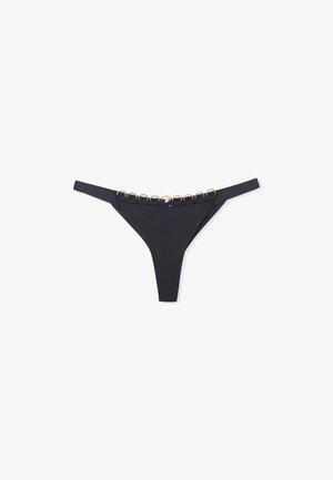 Bikini minimalista nero con una texture liscia e sottili cinturini laterali, caratterizzato da una fila di accenti circolari dorati nella parte superiore.
