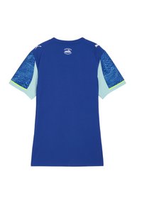 Niebieska sportowa koszula z jasnoniebieskim pikselowym wzorem na rękawach i małymi białymi logo na ramionach, widoczna z tyłu.