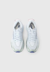 Hvite løpesko i mesh med blå og grønne detaljer, med rund tå, polstret såle og snøring. Røde trekkfaner på hælen.