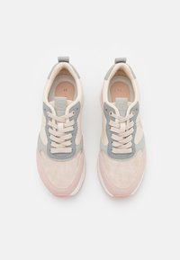 Light pink and gray sneakers feature a textured fabric upper, lace closure, and rubber outsole. Notable for the logo on the tongue.