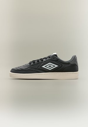 Μαύρο χαμηλό sneaker με λευκή σόλα και διπλό λευκό λογότυπο διαμάντι στο πλάι, εμφανίζεται σε πλευρική όψη σε ουδέτερο φόντο.