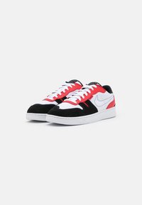 Nike-sneakers med svart mocka, röda och vita meshpaneler samt vita snören. Har en svart tunga och vit gummisula.