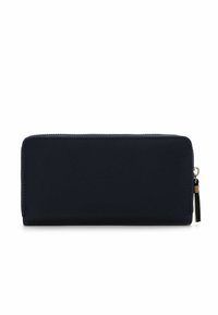 Portafoglio blu navy con zip, dalla superficie liscia, forma rettangolare e un piccolo pendaglio sulla cerniera. Design minimalista senza decorazioni.