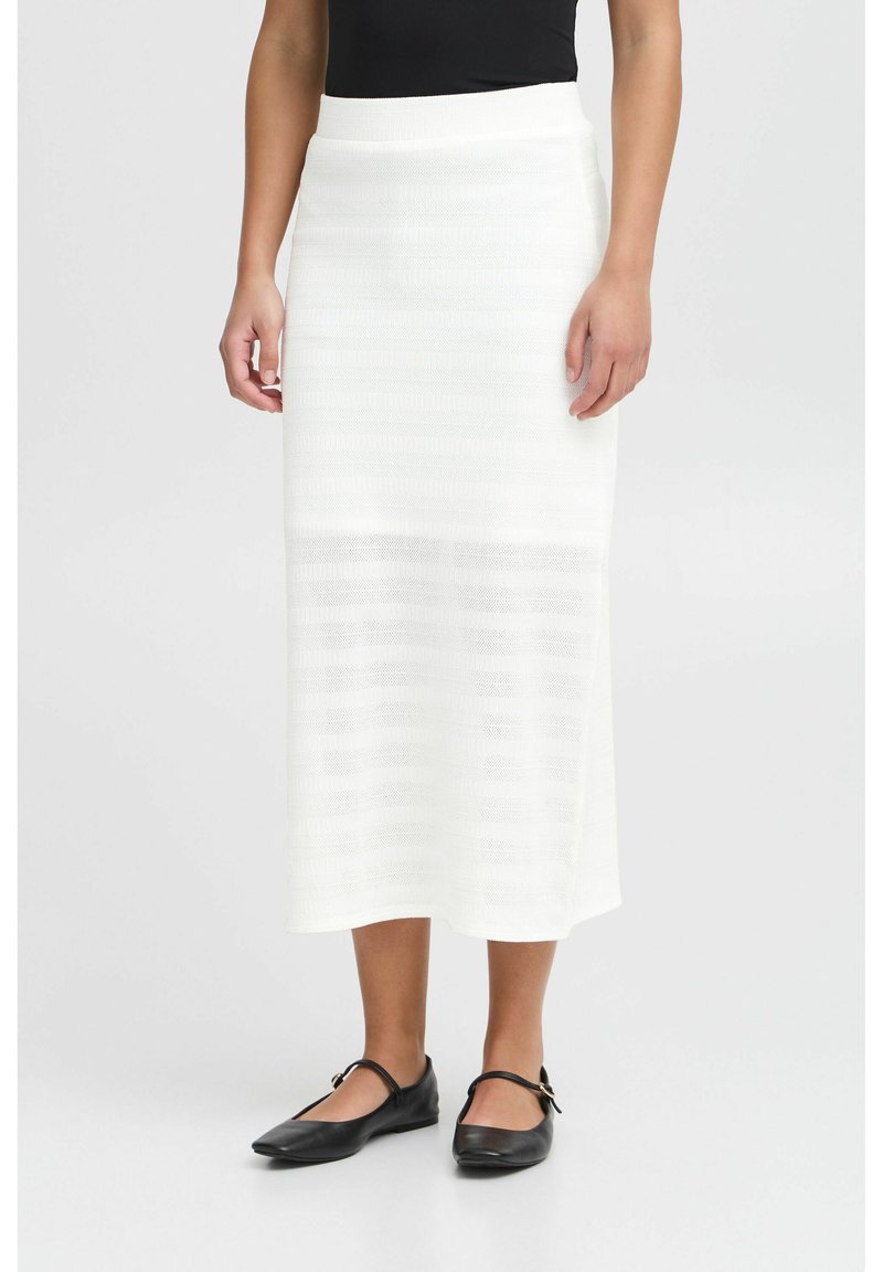 Witte gebreide midi-skirt met een textuur van strepen, een aansluitende tailleband en een rechte silhouet. Gecombineerd met zwarte platte schoenen.